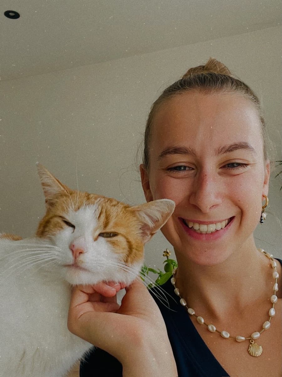 Lisa met haar kat, met een parelketting en gouden oorbellen van Le Chat D'Or